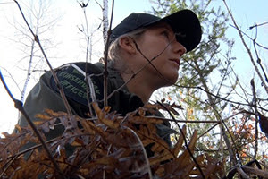 female conservation officer in woods, observing