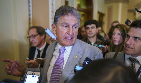 Sen. Joe Manchin, D-W.Va., a key negotiator in the infrastructure talks, is surrounded by reporters as walks through the Capitol in Washington, Tuesday, July 13, 2021. (AP Photo/J. Scott Applewhite)