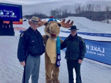 NY state police, moose mascot, and an ECO pose for a picture during the winter games