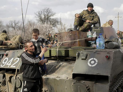 Un hombre y su hijo, junto a soldados ucranianos en un vehículo de combate que toma posiciones en la región de Donetsk, Ucrania, el 16 de abril del 2014. EFE/Anastasia Vlasova