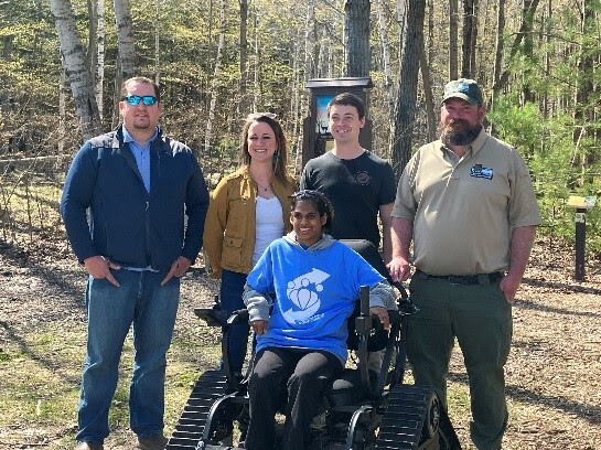 people standing next to an adaptive wheelchair at peninsula state park