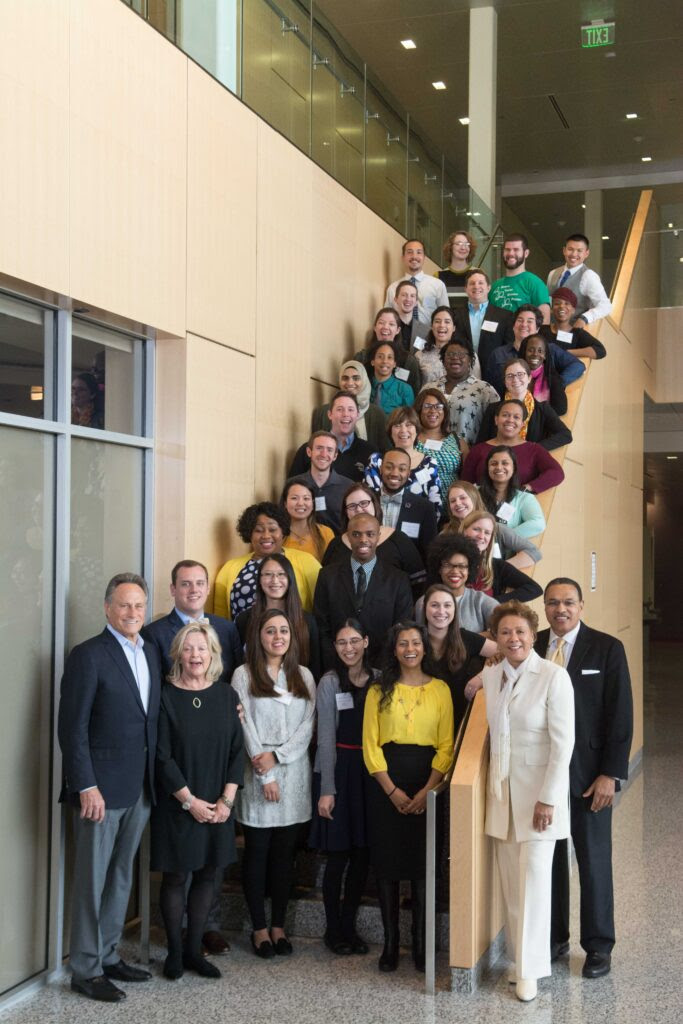 Group poses on a staircase in professional attire.