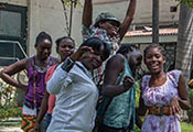 Group of teenagers in outdoor courtyard in Haiti pose for camera