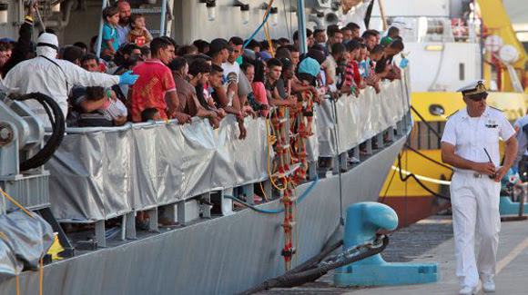 Inmigrantes se preparan para desembarcar en Sicilia, a final de julio. Foto: Giovanni Isolino / AFP.