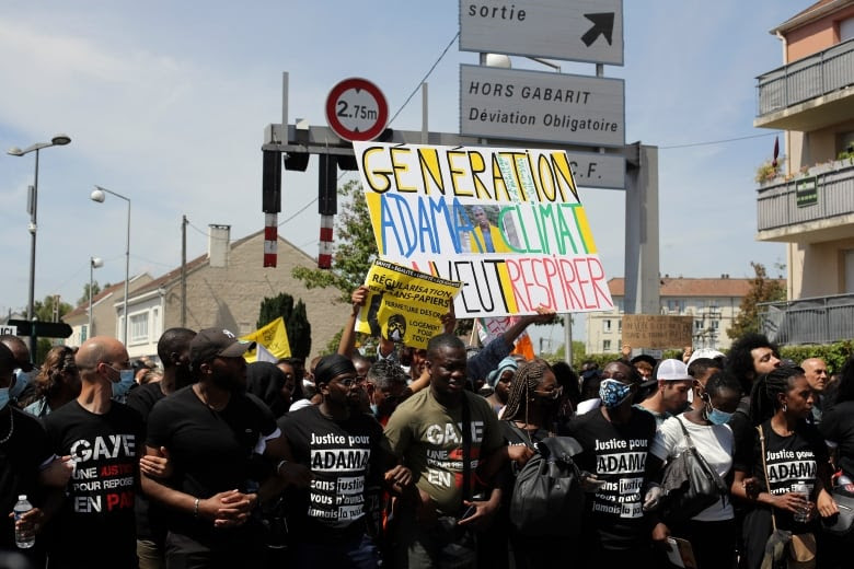 Demonstrators holding a placard reading 'Generation Adama-Climate, we want to breathe' take part in a march outside Paris in July 2020 to mark the fourth anniversary of Traore's death. (Rafael Yaghobzadeh/The Associated Press)
