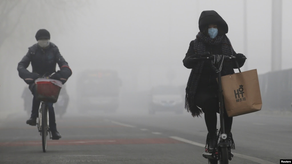 People ride amid the smog in Beijing, China, Feb. 14, 2017.