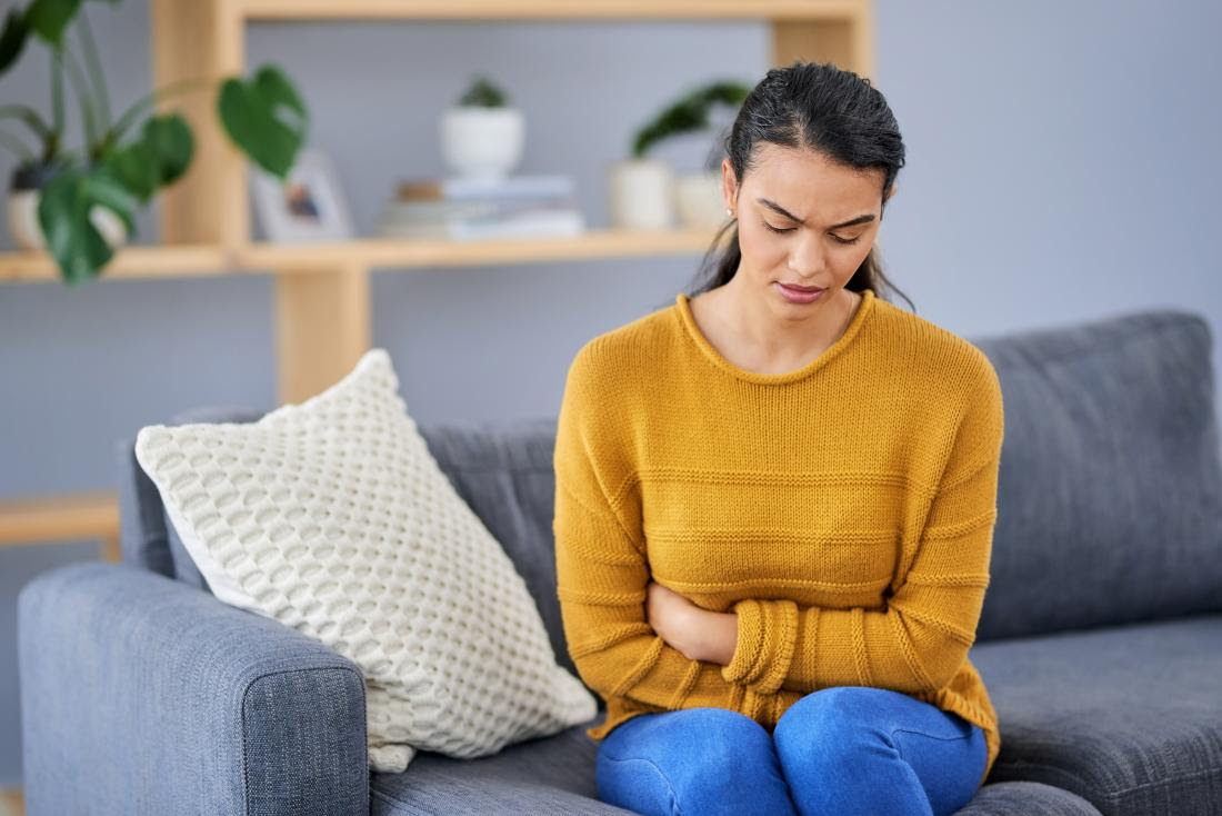 a woman holding her stomach because she suffers from Bowel disorders