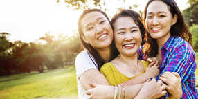 Asian Daughters Hugging Mom; Smiling