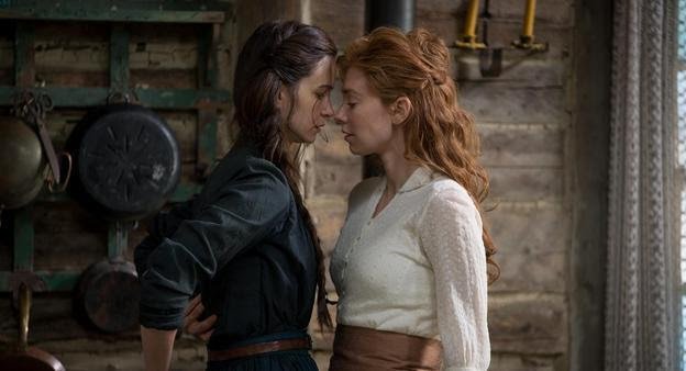Katherine Waterston and Vanessa Kirby almost embrace in a barn