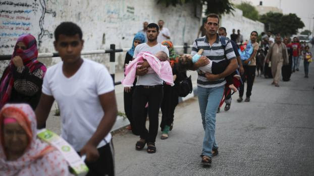 Des familles palestiniennes fuient leur domicile, en raison des bombardements isra&eacute;liens, le 23 juillet 2014, dans le sud de la bande de Gaza.