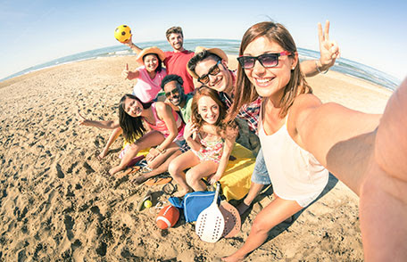 Un grupo de personas en la playa tomando una foto de sí mismos