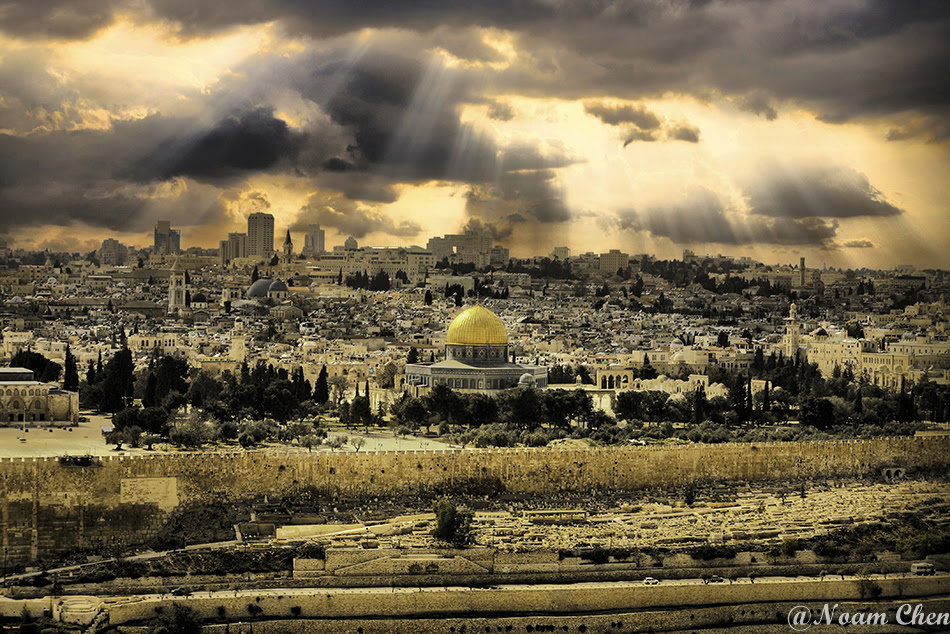 sun rays shining above the old city of jerusalem