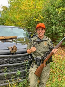 Michigan Conservation Officer Jennifer Hanson is pictured with recovered firearms.