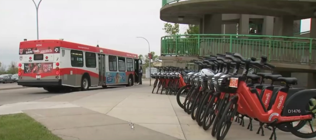 A row of e-bikes in the foreground, a bus in the background