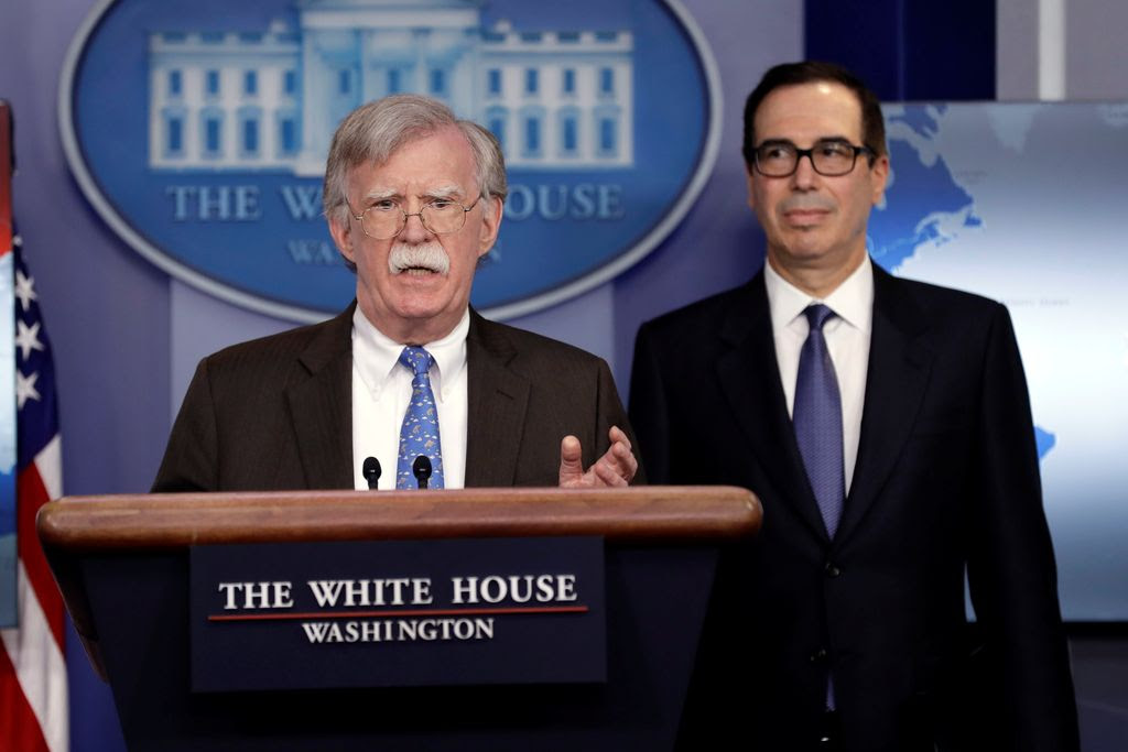 National security adviser John Bolton speaks as Treasury Secretary Steven Mnuchin listens during a press briefing at the White House on Monday.