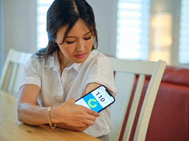Home Healthcare A woman taking care of her health at home by checking her blood glucose level. healthy blood sugar stock pictures, royalty-free photos & images