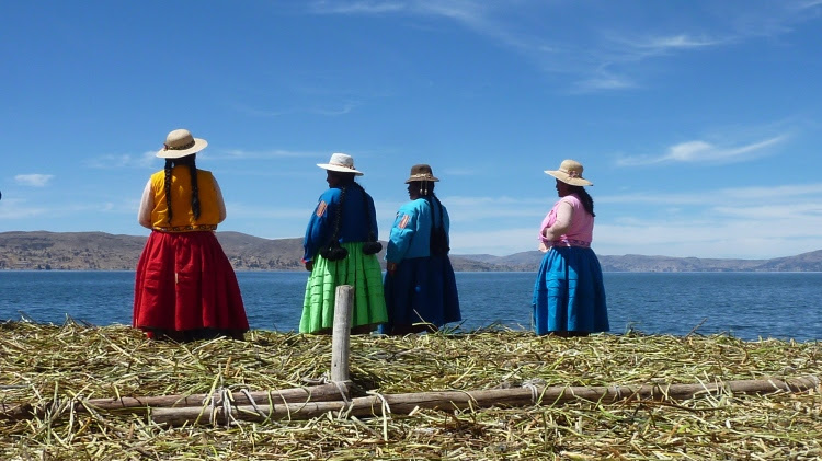 Uros women waiting for their guests to arrive on one of the floating islands, Lake Titicaca, Peru