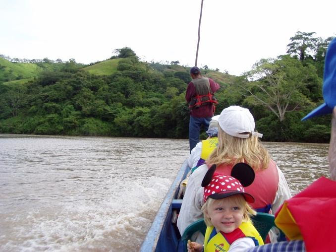 Child with parents inside a boat going down the river