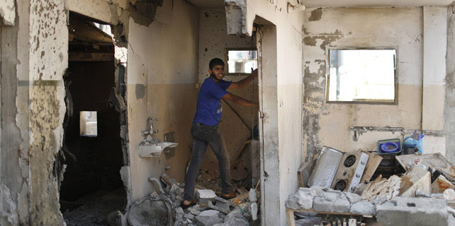 Un palestino inspecciona una casa destruída por un ataque israelí que mató a 8 de los miembros de la familia al-Qassas, el 21 de julio de 2014. REUTERS/Suhaib Salem.