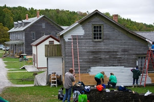 Volunteers begin painting a building after the siding has been repaired at Fayette Historic State Park. volunteers painting exterior of a Fayette building