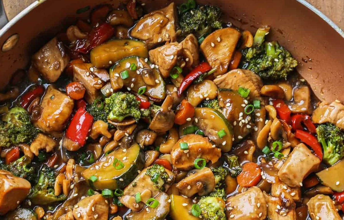 a colorful pan of saucy veggies with chicken