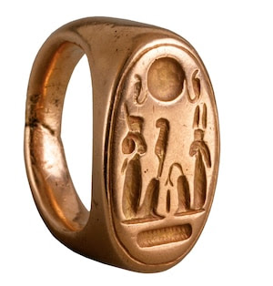 A golden ring with figures carved on the front