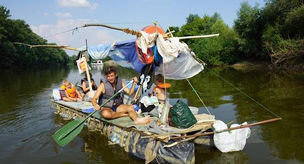 A man sails a boat made of trash