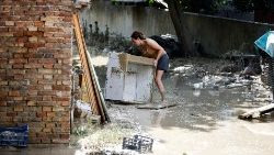 MArche, una donna ripulisce dalle rovine un'area colpita dall'alluvione