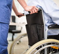 An attendant pushing a patient in a wheelchair
