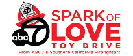 Words "Spark of Love Toy Drive" with a fire helmet