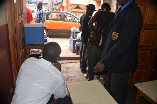 Un migrant demandant la nationalité cameounaise (g) dans un restaurant à Yaoundé le 27 avril 2015 © Reinnier Kaze AFP