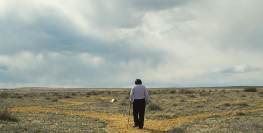 A photograph of James Finley walking along a desert path.