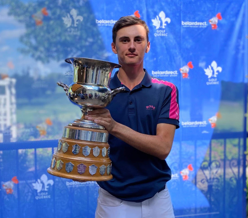 Un golfeur souriant qui tient un trophée.