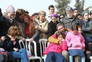 Daphna Meir's husband Natan and their children sit in grief during funeral.