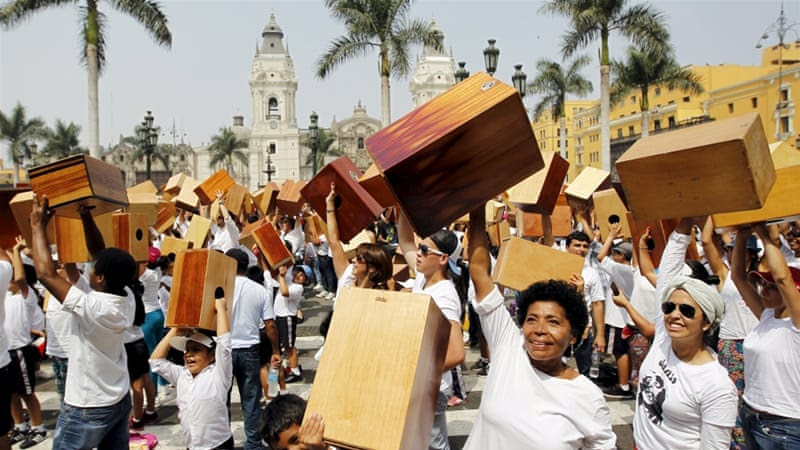 Peruvians hold up their cajones, a traditional musical instrument, in celebration [Reuters]