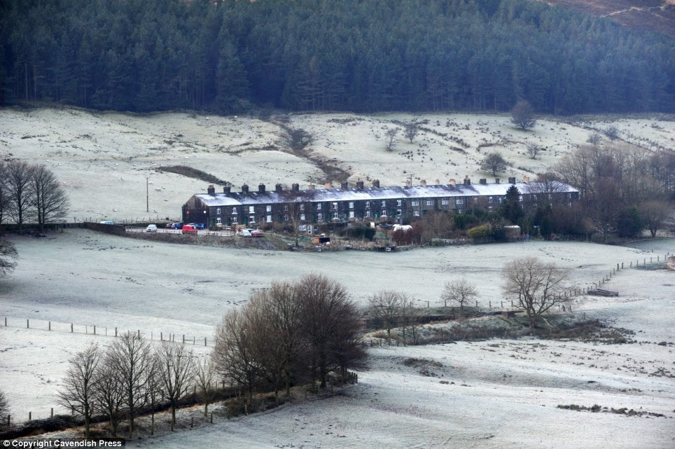 Snowy lane: A row of houses at Dove Stone Reservoir in Oldham, Greater Manchester are covered in snow and frost
