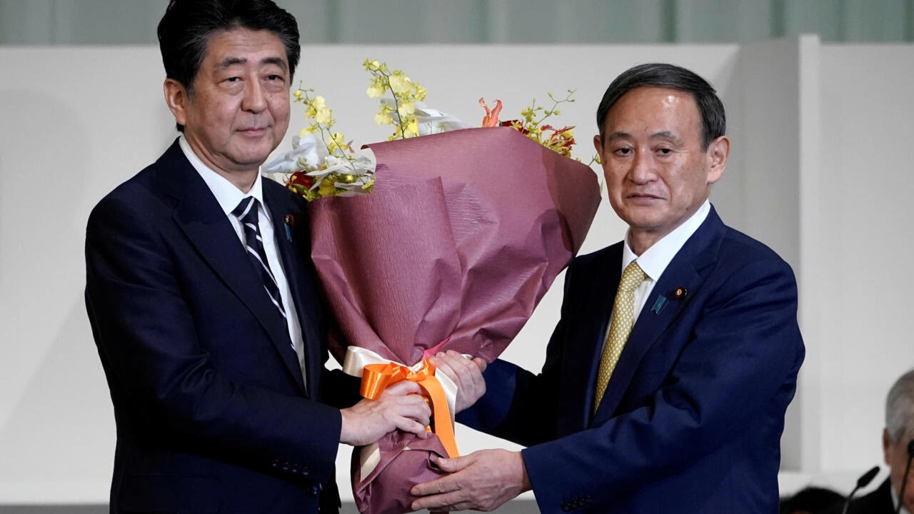 Thủ tướng Nhật Bản đã từ nhiệm Shinzo Abe (T) tặng hoa cho chánh văn phòng nội các Yoshihide Suga sau khi nhân vật này được bầu làm lãnh đạo mới của đảng Dân Chủ Tự Do (LDP) ở Tokyo, Nhật Bản ngày 14/09/2020.