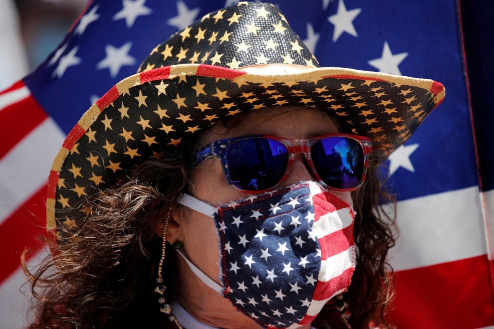Un manifestante con una máscarilla con los colores de la bandera de EEUU en una protesta contra el cierre de actividad y de negocios decretado por la pandemia del coronavirus, en Los Ángeles (California, EEUU). REUTERS / Mike Blake