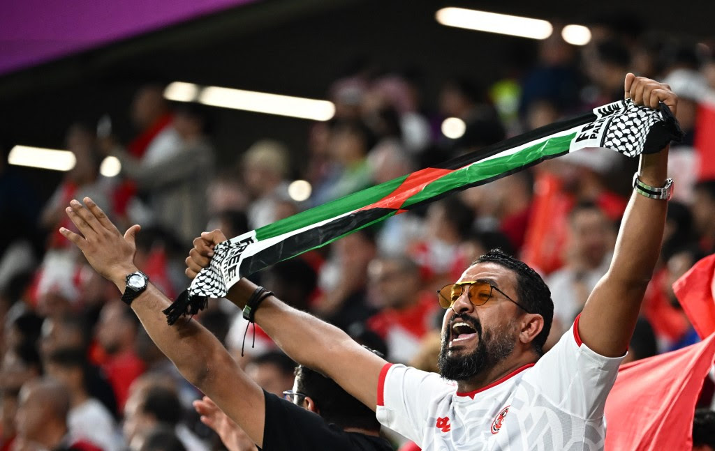 A fan holds up a 'Free Palestine' scarf in the crowd after the Qatar 2022 World Cup Group D football match between Denmark and Tunisia at the Education City Stadium in Al-Rayyan, west of Doha on November 22, 2022. Anne-Christine POUJOULAT / AFP