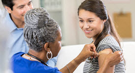 nurse applying bandaide to patient after giving vaccination