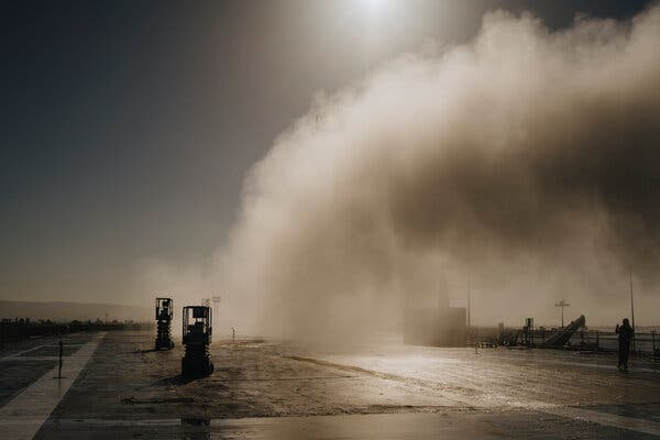 A column of mist rises into the air from the deck of an old aircraft carrier.