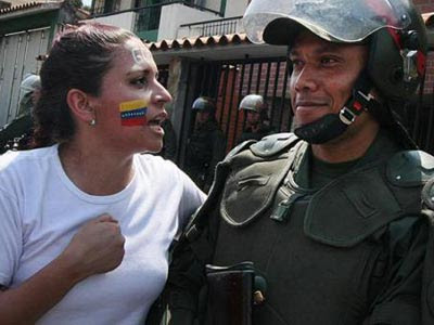 Una manifestante opositora junto a un miembro de las Fuerzas Armadas.