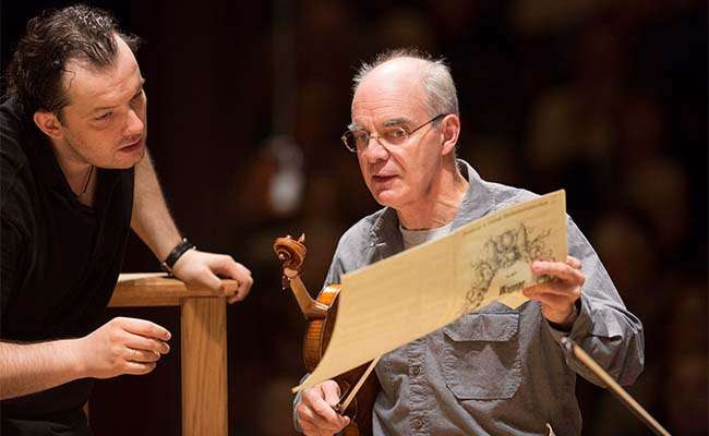 [Malcolm Lowe and Andris Nelsons look over score during rehearsal; Photo by Marco Borggreve]