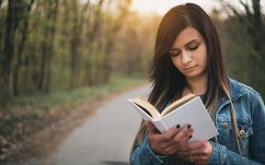Young girl reading book outdoor