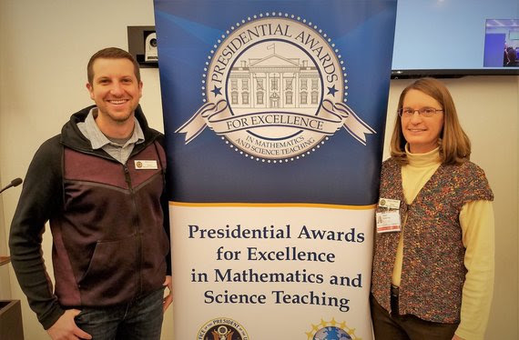 The WDE math and science standards consultants stand on either side of a banner with reads, "Presidential Awards for Excellence in Mathematics and Science Teaching."
