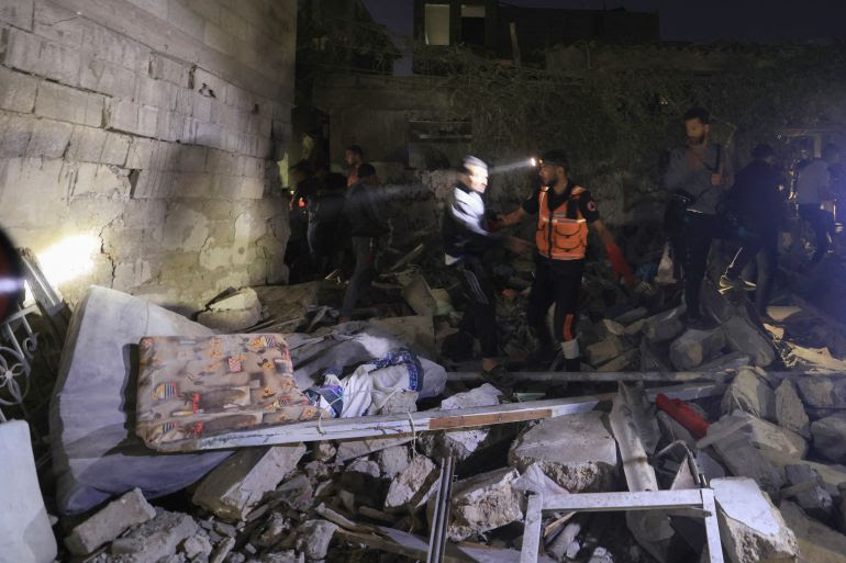 Palestinian emergency personnel and residents inspect the rubble of a building for survivors following Israeli strikes in Khan Yunis in the southern Gaza Strip on November 15, 2023, amid ongoing battles between Israel and the Palestinian group Hamas. (Photo by MAHMUD HAMS / AFP)