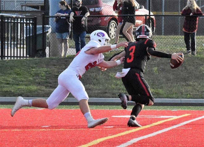 Owen Valley's Cale Nickless pressures Edgewood quarterback Jacob Murphy in Friday's football game at Edgewood.