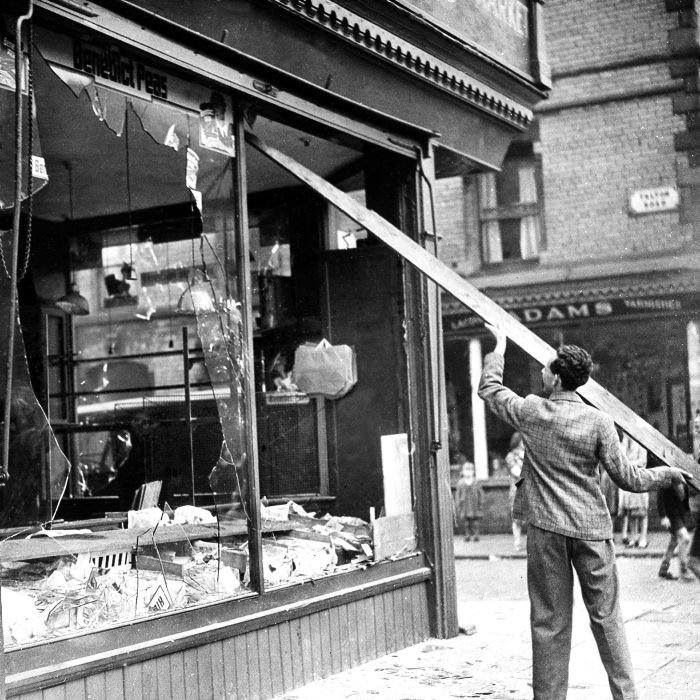 A workman knocks down the hanging glass in a shop window, Aug. 5, 1947, in Liverpool, England, which was damaged during anti-Semitic riots. Incidents have flared in many British cities and more than a score of demonstrators have been arrested in Liverpool. (AP Photo)
