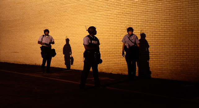 Agentes de la policía antidisturbios durante las protestas nocturnas en la ciudad de Ferguson, Misuri.
