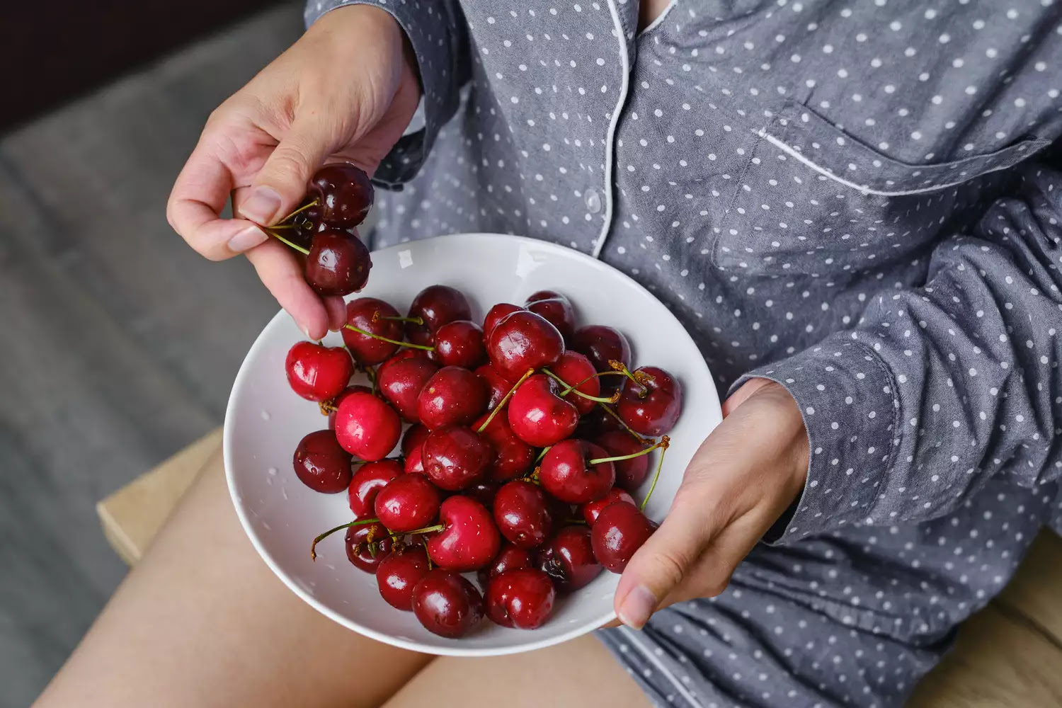 woman holding a bowl of cherries